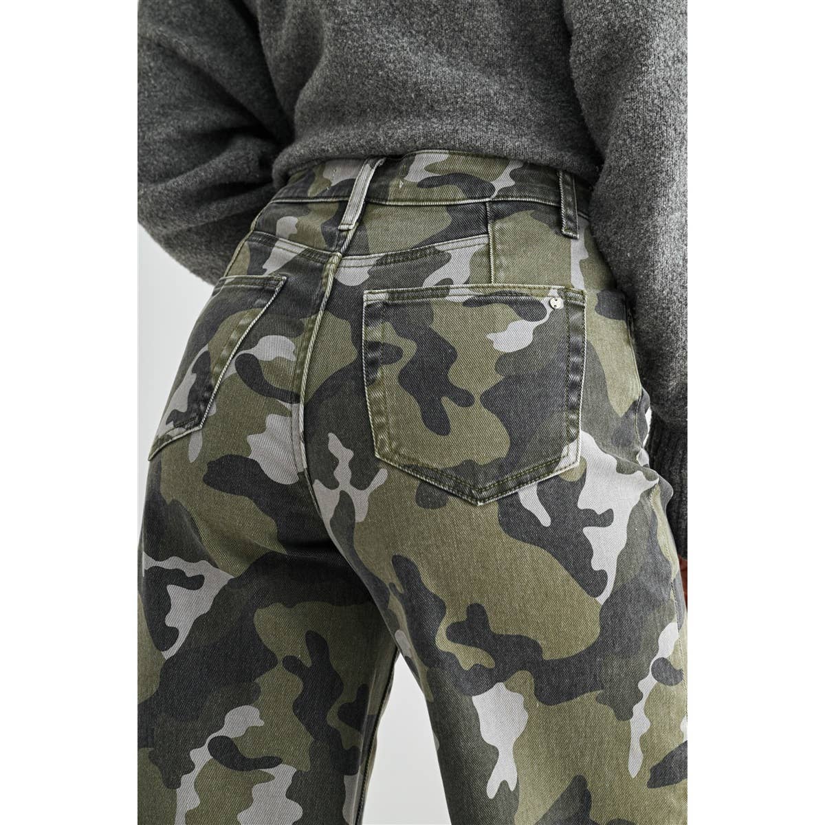 Camouflage pants worn by a person with a gray sweater on a white background