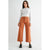 Woman wearing a white sweater and brown pants on a white background