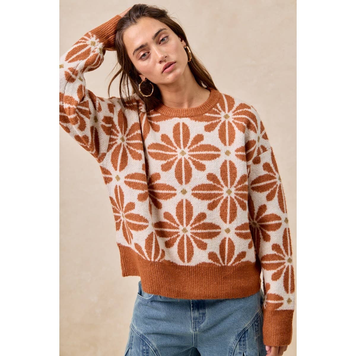 Woman wearing a patterned sweater with a neutral background